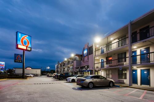 a parking lot with cars parked in front of a hotel at Motel 6 Houston, TX - Medical Center - NRG Stadium in Houston