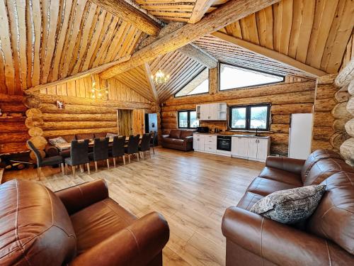 a large living room with leather furniture and a kitchen at Alliku holiday home in Alliku