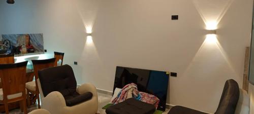 a living room with two chairs and a tv at APARTAMENTO. ALQUILER POR DÍAS in San José del Fragua