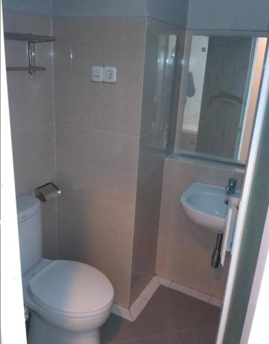 La salle de bains est pourvue de toilettes et d'un lavabo. dans l'établissement D’Coz Surya Living Pakuwon, à Surabaya