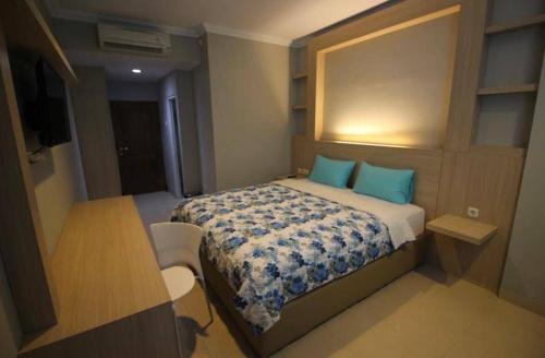 a small bedroom with a bed with blue pillows at D’Coz Surya Living Pakuwon in Surabaya