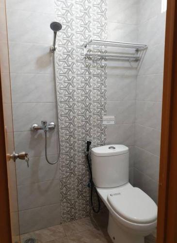 a bathroom with a toilet and a shower at D’Coz Surya Living Pakuwon in Surabaya