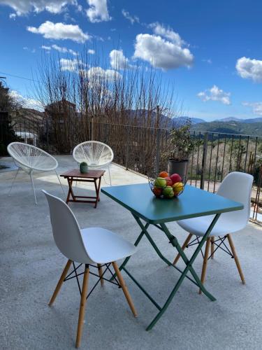 three chairs and a table with a bowl of fruit on it at Très beau studio avec terrasse in Zonza