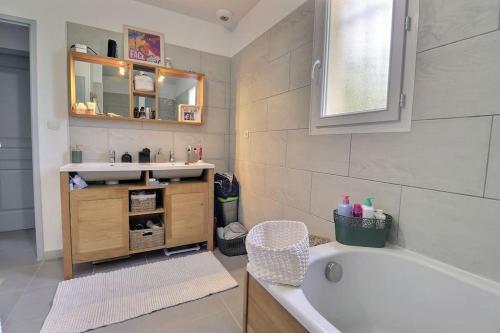une salle de bain avec une baignoire, un lavabo et un miroir dans l'établissement Maison cocooning varoise !, à Seillons-Source-dʼArgens