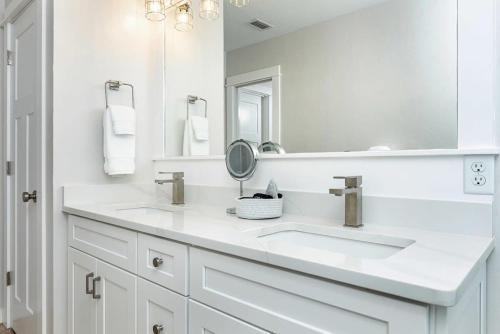 a white bathroom with two sinks and a mirror at 3 Story Haven Fire Pit kayaks updated 360 Views in Cedar Key