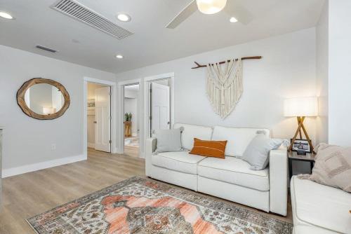 a living room with a white couch and a mirror at 3 Story Haven Fire Pit kayaks updated 360 Views in Cedar Key