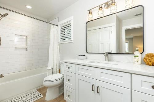 a bathroom with a sink and a toilet and a mirror at 3 Story Haven Fire Pit kayaks updated 360 Views in Cedar Key