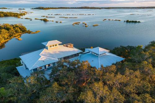 an aerial view of a house in the middle of a lake at 3 Story Haven Fire Pit kayaks updated 360 Views in Cedar Key