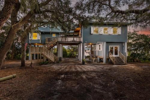 a blue house with a staircase leading up to it at 3 Story Haven Fire Pit kayaks updated 360 Views in Cedar Key