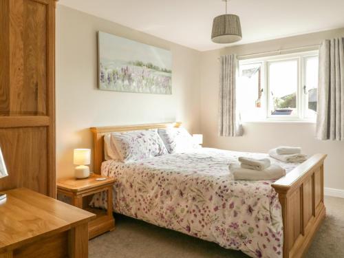 a bedroom with a bed and a table and a window at Bramley Cottage in Clacton-on-Sea