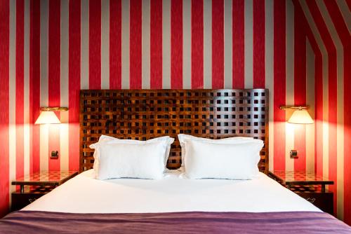 a bedroom with a large bed with two lamps at Villa Panthéon in Paris