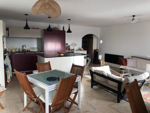 a kitchen and a living room with a table and chairs at La terrasse des capucines in Sète