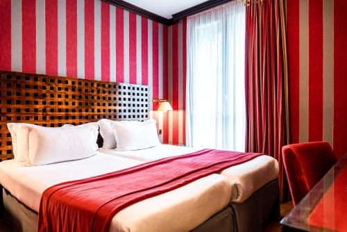a bedroom with a bed with a red and white striped wall at Villa Panthéon in Paris