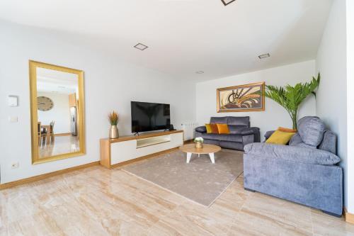 a living room with a blue couch and a mirror at Casa de Eiró by House and People in Barcelos