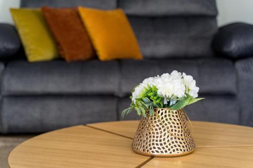 a vase with white flowers sitting on a table at Casa de Eiró by House and People in Barcelos