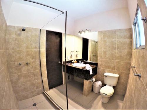 a bathroom with a shower and a toilet and a sink at Hotel LunaSol in Playa del Carmen