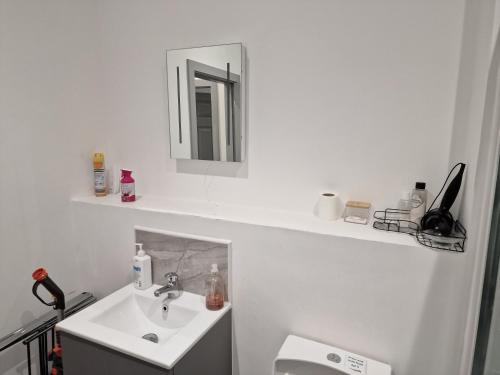 a white bathroom with a sink and a mirror at Home away from home in Brierley Hill