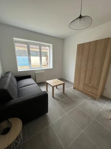 un salon avec un canapé noir et une table dans l'établissement Studio indépendant, à Bron