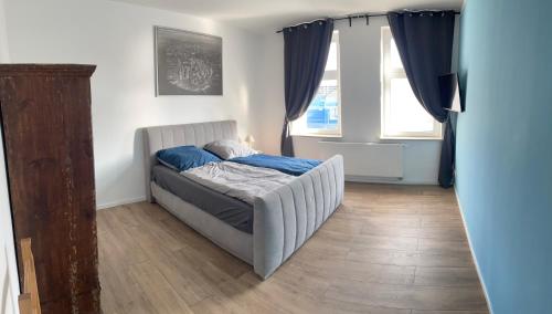 - une chambre avec un lit doté de draps bleus et 2 fenêtres dans l'établissement Zum Karl, à Wurzen