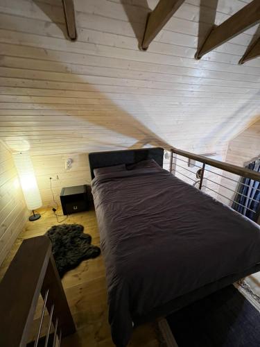 Bett in einem Zimmer mit einer Holzwand in der Unterkunft Zona de odihnă Sirius in Chişinău