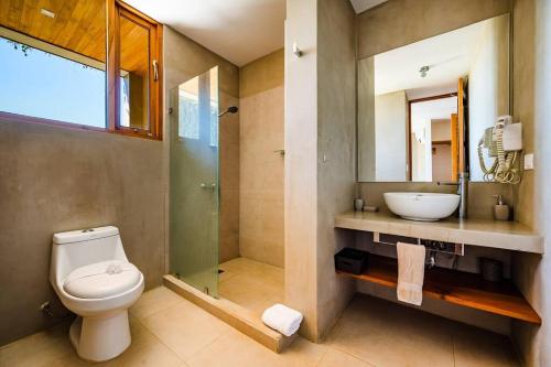 ein Badezimmer mit Toilette, Waschbecken und Spiegel in der Unterkunft Spacious & Serene With Partial Ocean & Jungle View in Tamarindo