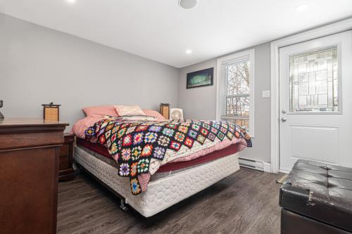 a bedroom with a bed with a blanket on it at Mi Casa Su Casa, Heart of Downtown St. John's, 1 BDRM Apt with Backyard in St. John's