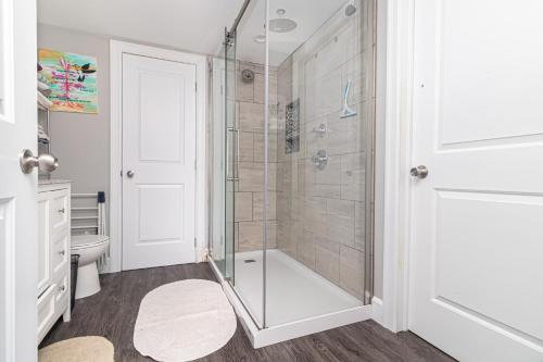 a bathroom with a shower with a glass door at Mi Casa Su Casa, Heart of Downtown St. John's, 1 BDRM Apt with Backyard in St. John's