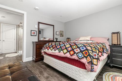 a bedroom with a bed and a dresser and a mirror at Mi Casa Su Casa, Heart of Downtown St. John's, 1 BDRM Apt with Backyard in St. John's