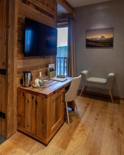 a room with a desk with a television and a chair at Asiago Sporting Hotel & Spa in Asiago