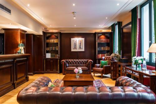 a living room with leather furniture and a table at Villa Panthéon in Paris