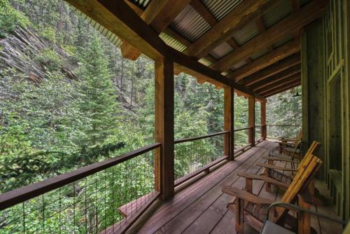 a porch of a cabin with chairs and trees at Silver King Lodge in Deadwood