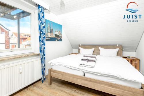 a small bedroom with a bed and a window at Landhaus Gertrude 105 - Wohnung Wattenmeer in Juist