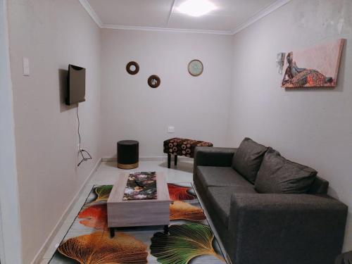 - un salon avec un canapé et une table dans l'établissement Reutlwane Gardens Apartments, à Secunda