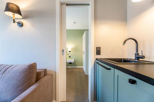 a kitchen with a sink and a couch in a room at Appartement Hamburg in Westerland