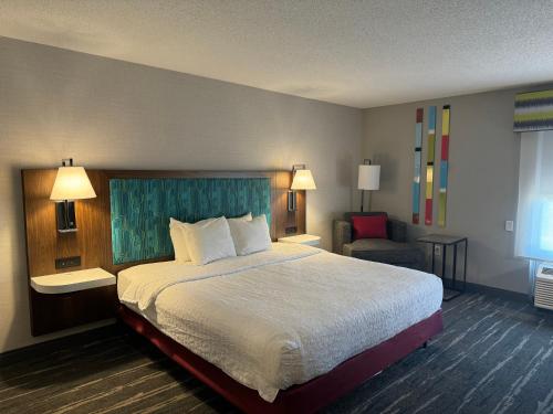 a hotel room with a large bed and a chair at Hampton Inn South Heritage Park in Lincoln