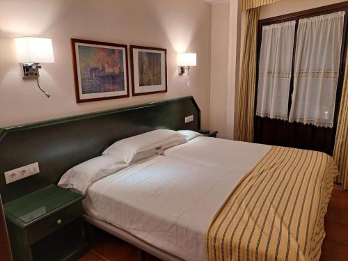 a bed in a bedroom with two lamps on the wall at Estudio Azul Paraíso in Llanes