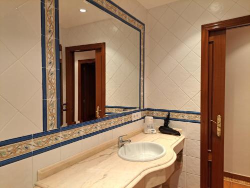 a bathroom with a sink and a large mirror at Estudio Azul Paraíso in Llanes