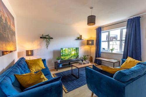 uma sala de estar com dois sofás azuis e uma televisão em Three Bedroom Home in Myddle em Myddle