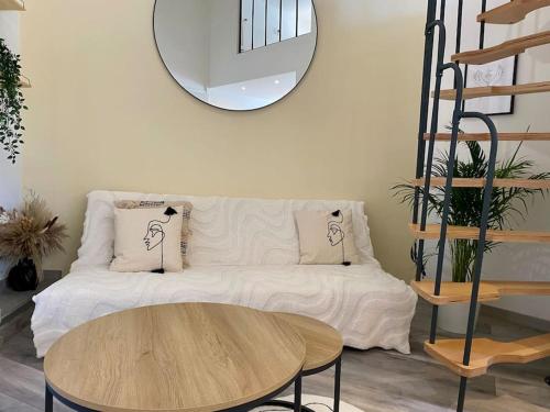 un salon avec un canapé blanc et un miroir rond dans l'établissement Le Cocon de la Gare de Grenoble, à Grenoble