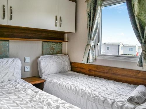 two beds in a small room with a window at Sea View 59 - Uk45586 in Mainsriddle