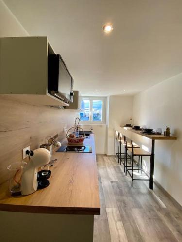 une cuisine avec un comptoir en bois dans une pièce dans l'établissement Le Cocon de la Gare de Grenoble, à Grenoble