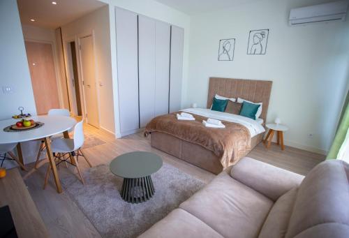 - une chambre avec un lit, une table et un canapé dans l'établissement inJoy, à Sajmište