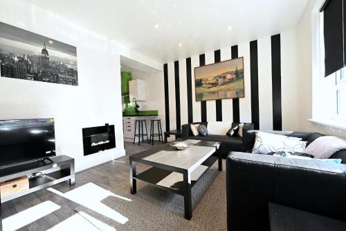a living room with a black and white striped wall at Vibrant 3BD home with great links to the city in London