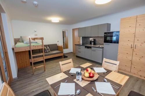 a room with a table and a kitchen and a bunk bed at nawu apartments & Restaurant in Hermagor