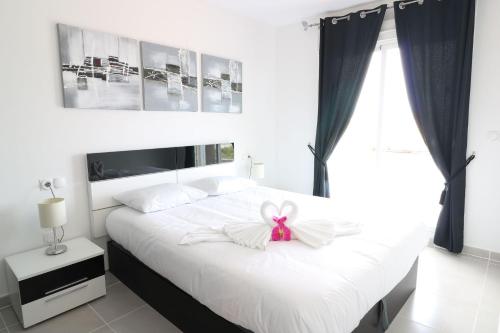 グラン・アラカントにあるNova Beach Paradise Apartmentのベッドルーム(弓を用いた白いベッド1台付)