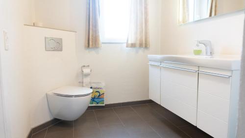 a bathroom with a white toilet and a sink at HotelVFjorden in Lemvig