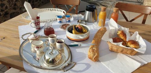 a table with a breakfast of croissants and bread at La Tour Noble in Saint-Saturnin