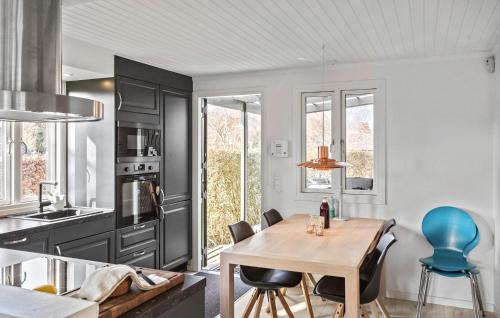 a kitchen with a wooden table and blue chairs at 3 Bedroom Gorgeous Home In Stubbekøbing in Stubbekøbing