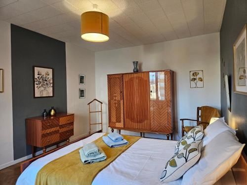 um quarto com uma cama grande e um armário de madeira em Les camélias em Selles-sur-Cher