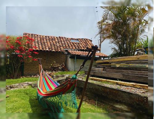 a hammock in a yard in front of a house at Hostal Camino Viejo in Líbano